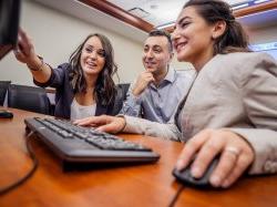 Students working on a computer in the School of Business