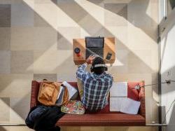 Photo of student studying on couch.